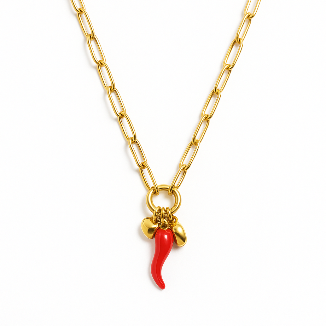 Gold chain necklace with red cornicello charm plus gold heart and bead accents, shown on model.
