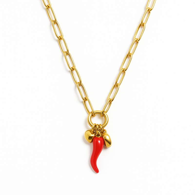 Gold chain necklace with red cornicello charm plus gold heart and bead accents, shown on model.